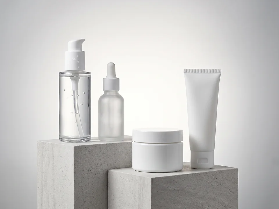 Linha de dermocosméticos sem rótulo, com frasco pump, conta-gotas, pote e bisnaga sobre blocos de pedra clara